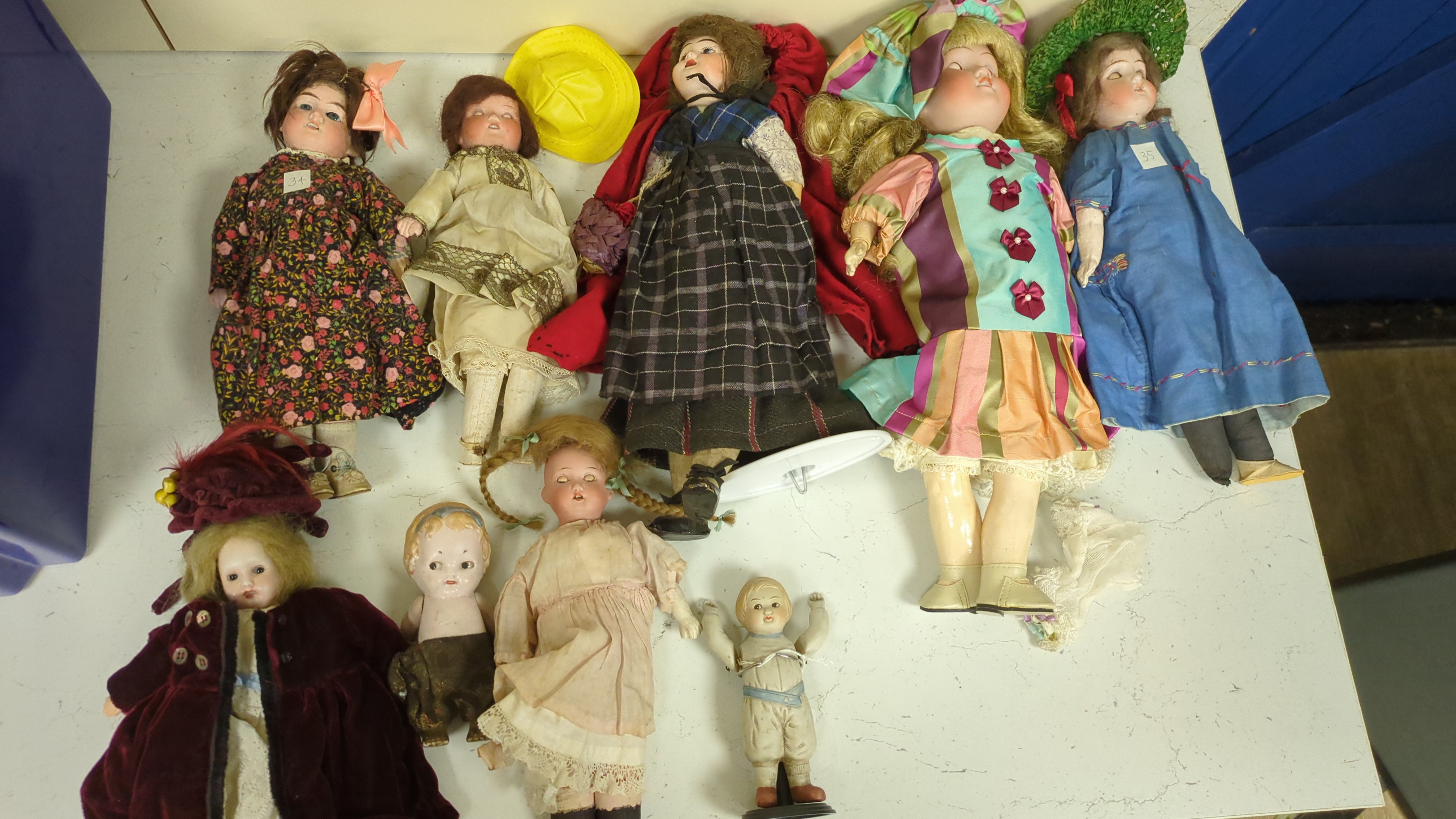 Nine assorted dolls including AMS and Kewpie small doll baby in cradle